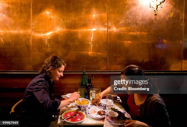 Patrons sit by the copper wall at at the Fatty 'Cue restaurant in the Brooklyn borough of New York, U.S., on Monday, May 17, 2010. Fatty 'Cue is the...