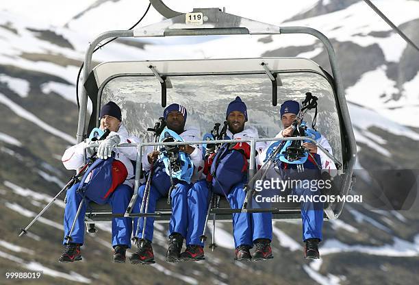France's football team's staff member Fabrice Grange and players William Gallas, Nicolas Anelka, and Jeremy Toulalan sit in a ski lift to reach the...