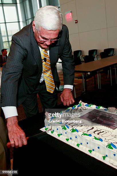 Robert "Bob" Lutz, former vice chairman of General Motors Co. , cuts a cake with a photo of a Chevrolet Malibu on it during a retirement party for...