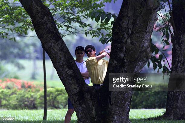 Felipe Aguilar of Chile hits a shot between the tree's trunk at the 18th hole during the Second Round of the Foursome Stroke Play during the Davidoff...