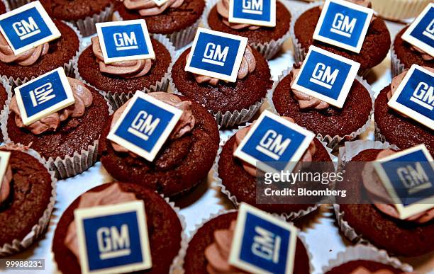 Cupcakes featuring General Motors Co. Logos are arranged during a retirement party for Robert "Bob" Lutz, former vice chairman of GM, at the...