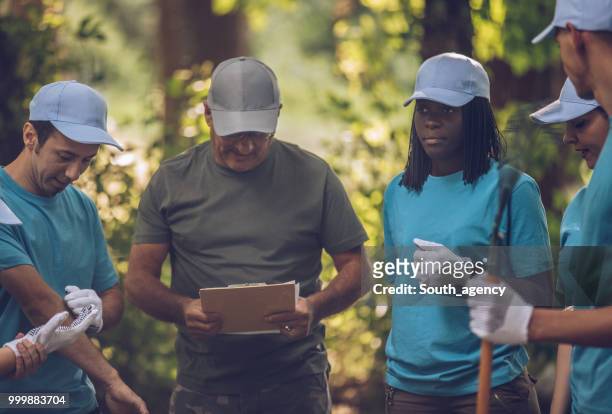 volunteers picking up trash - south_agency stock pictures, royalty-free photos & images