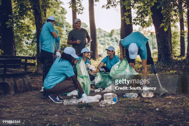 young volunteers collecting garbage in park - south_agency stock pictures, royalty-free photos & images