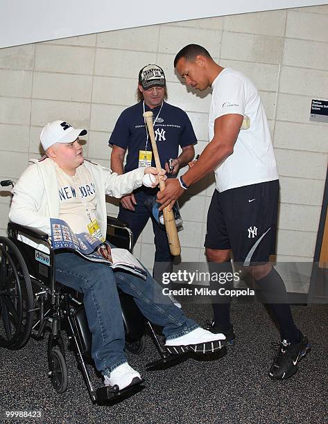 Jack Williams and Roger Williams have a bat signed by New York Yankees 3rd baseman Alex Rodriguez at the starter event at NY Yankees batting practice...