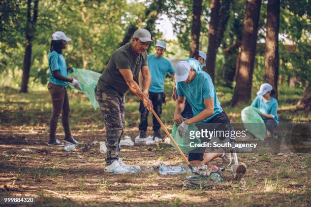 volunteers cleaning up garbage in public park - south_agency stock pictures, royalty-free photos & images