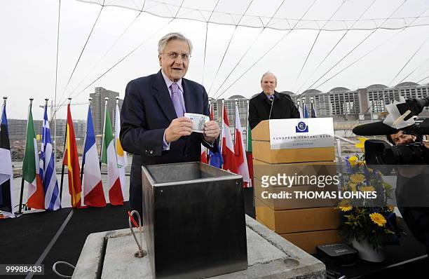 European Central Bank President Jean-Claude Trichet holds up Euro bank notes before putting them in a box to be buried with the corner-stone of the...