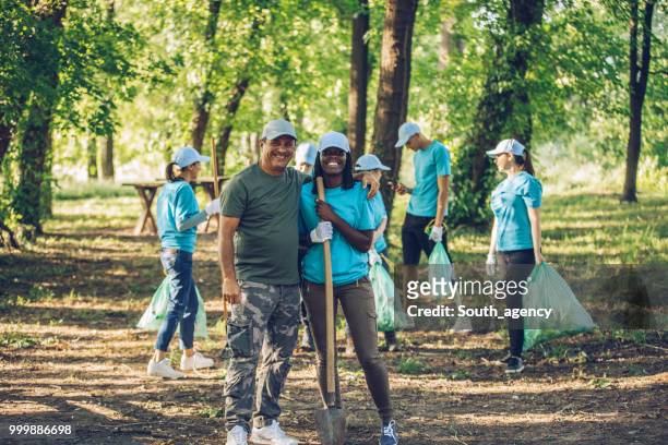 volunteers with garbage bags in park - south_agency stock pictures, royalty-free photos & images