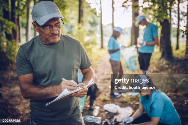 people collecting rubbish in public park - south_agency stock pictures, royalty-free photos & images