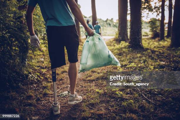 Young volunteers collecting garbage in public park