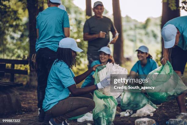 voluntarios recogiendo basura en parque público - south_agency fotografías e imágenes de stock