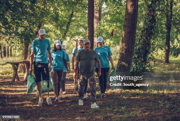group of volunteers cleaning up garbage in public park - south_agency stock pictures, royalty-free photos & images