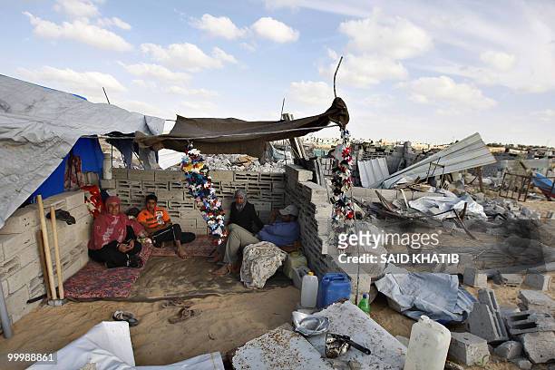 Palestinian family sits under a makeshift tent next to the rubble of houses which were demolished by Hamas security forces in Rafah in the southern...