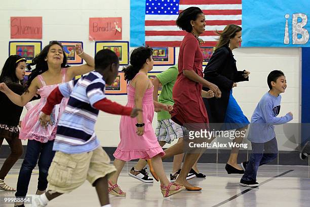 First lady Michelle Obama and her Mexican counterpart Margarita Zavala run with second graders during a physical education class as they visit New...