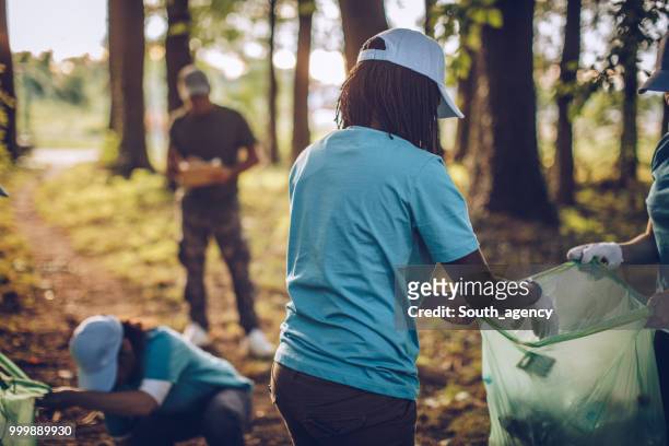 volunteers collecting rubbish in public park - south_agency stock pictures, royalty-free photos & images