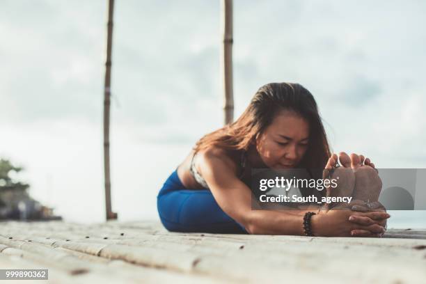 mujer haciendo ejercicios de yoga  - south_agency fotografías e imágenes de stock