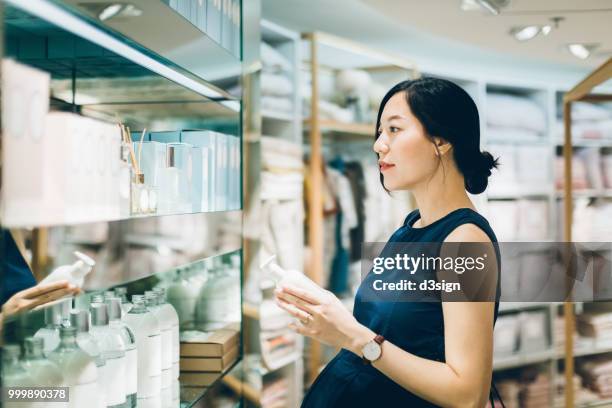 beautiful pregnant woman shopping for beauty products in shopping mall - bottle shop stock-fotos und bilder