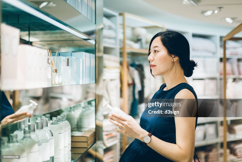 Beautiful pregnant woman shopping for beauty products in shopping mall