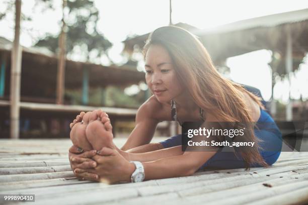 woman doing yoga exercises at the beach - south_agency stock pictures, royalty-free photos & images