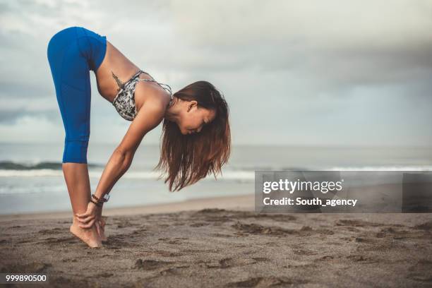 beautiful woman stretching at the beach - south_agency stock pictures, royalty-free photos & images