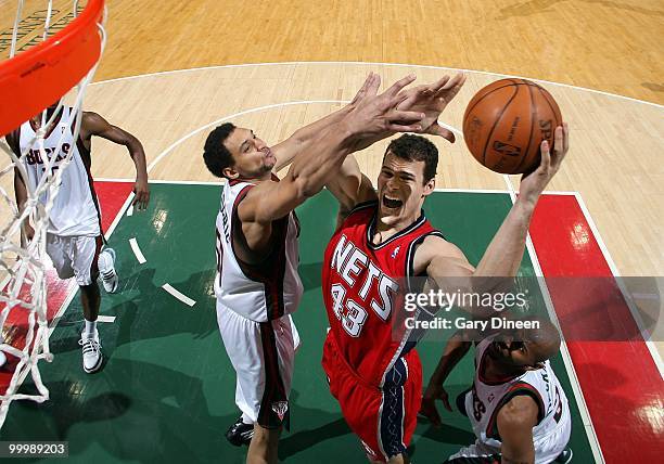 Kris Humphries of the New Jersey Nets puts a shot up against Dan Gadzuric of the Milwaukee Bucks during the game at the Bradley Center on April 7,...