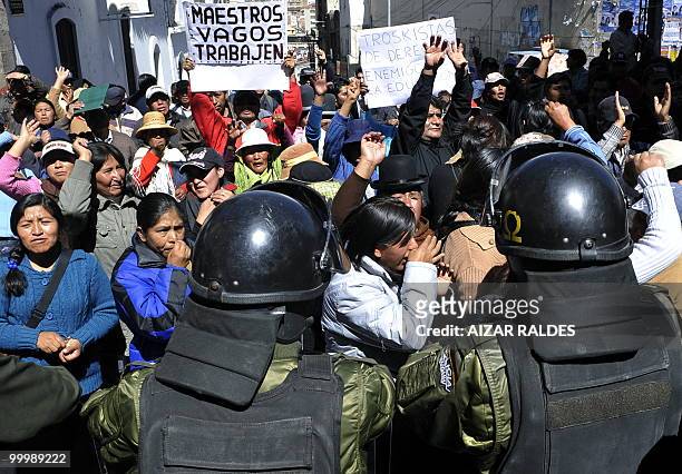 Realtives of Bolivian students shout slogans next to riot policemen during a protest against a general strike set up since 10 days by workers from...