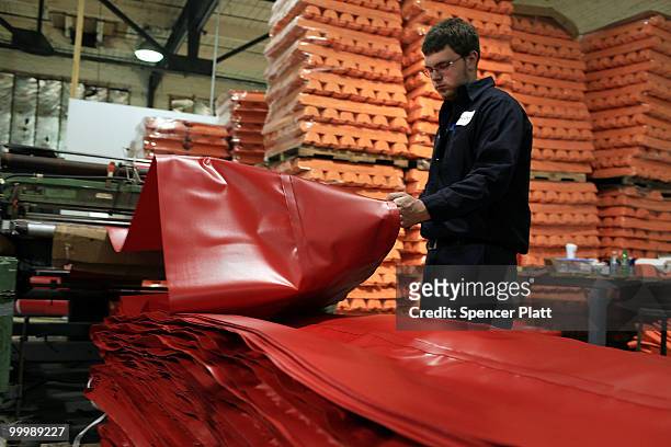 Worker at Slickbar Products, a company that makes oil booms and other products designed to clean up oil spills, manufactures an oil boom on May 19,...