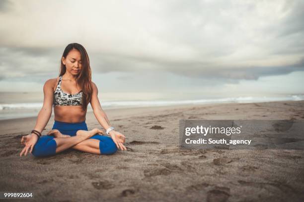 beautiful woman doing yoga meditation exercises - south_agency stock pictures, royalty-free photos & images