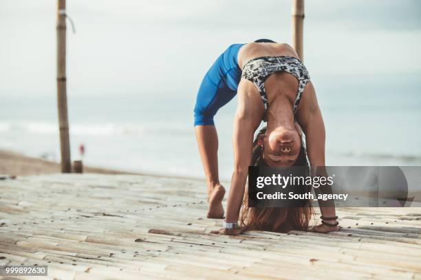 young woman doing yoga exercises - south_agency stock pictures, royalty-free photos & images