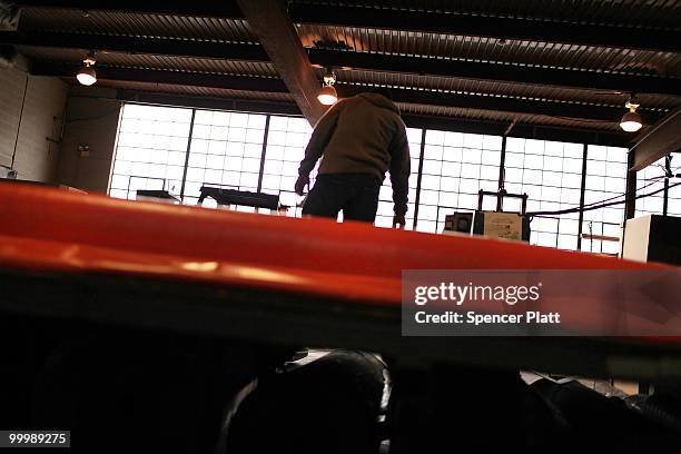 Worker at Slickbar Products, a company that makes oil booms and other products designed to clean up oil spills, manufactures an oil boom on May 19,...