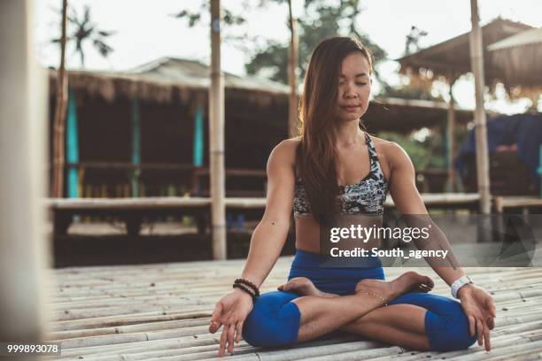 mujer haciendo yoga, ejercicios de meditación - south_agency fotografías e imágenes de stock