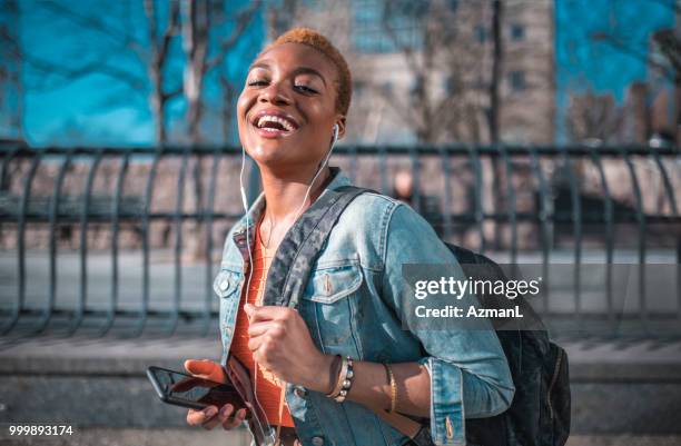 jonge vrouw houden van mobiele telefoon en luisteren naar muziek - fashion pretty woman listening music in headphones with smartphone colorful stockfoto's en -beelden