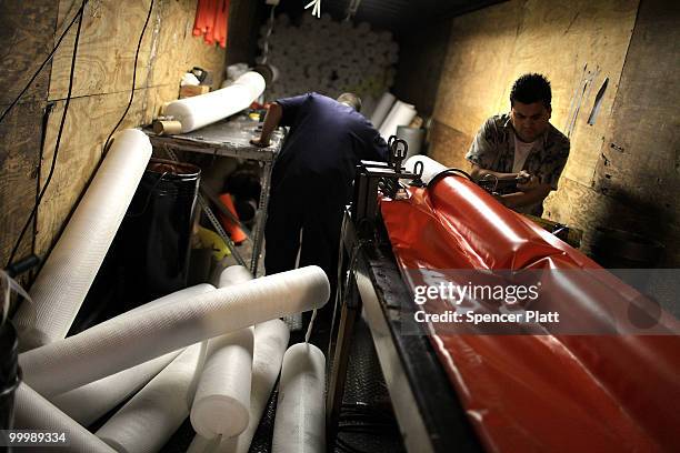 Worker at Slickbar Products, a company that makes oil booms and other products designed to clean up oil spills, manufactures an oil boom on May 19,...