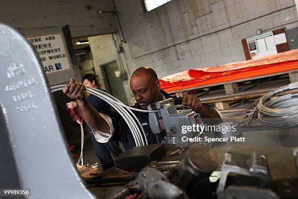 Worker at Slickbar Products, a company that makes oil booms and other products designed to clean up oil spills, manufactures an oil boom on May 19,...