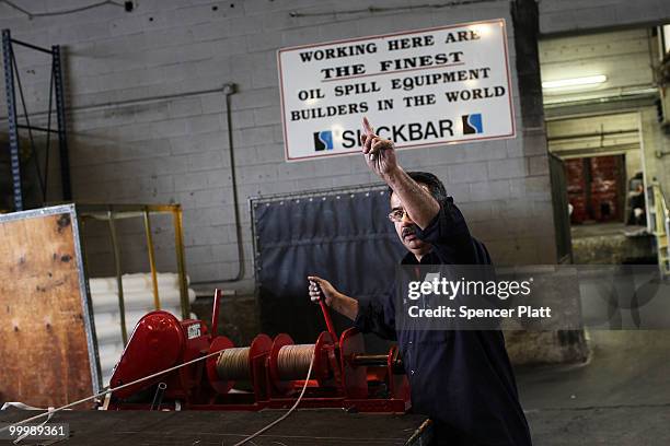 Worker at Slickbar Products, a company that makes oil booms and other products designed to clean up oil spills, manufactures an oil boom on May 19,...