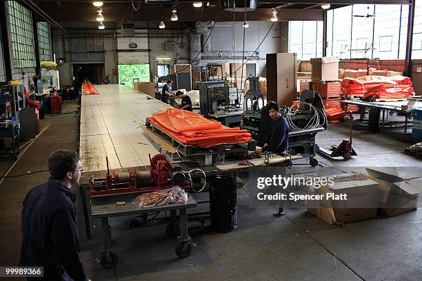 Worker at Slickbar Products, a company that makes oil booms and other products designed to clean up oil spills, manufactures an oil boom on May 19,...