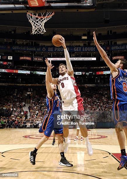 Marco Belinelli of the Toronto Raptors goes to the basket against Sergio Rodriguez and Danilo Gallinari of the New York Knicks during the game at Air...