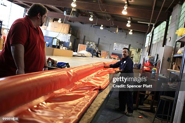 Worker at Slickbar Products, a company that makes oil booms and other products designed to clean up oil spills, manufactures an oil boom on May 19,...