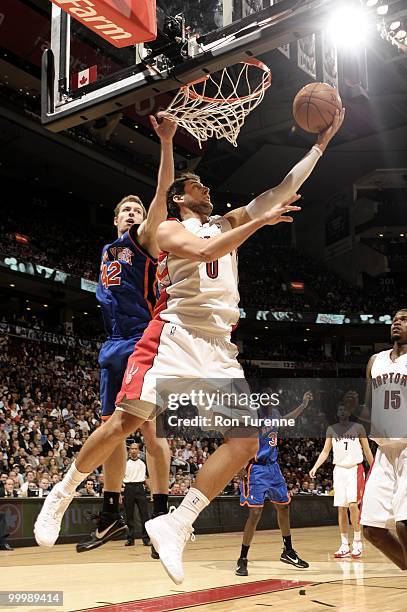 Marco Belinelli of the Toronto Raptors goes to the basket against David Lee of the New York Knicks during the game at Air Canada Centre on April 14,...