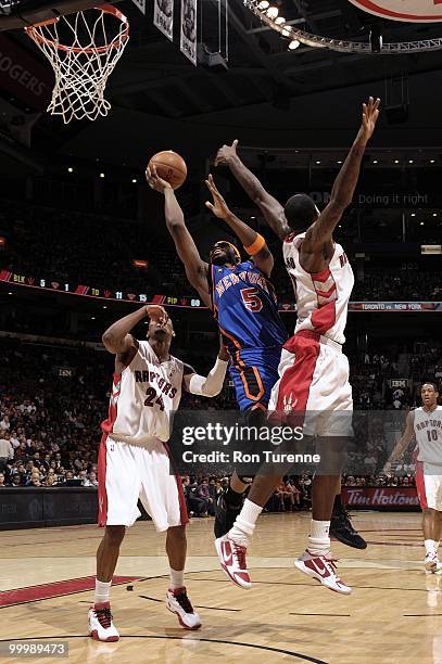 Bill Walker of the New York Knicks goes to the basket against Sonny Weems and Amir Johnson of the Toronto Raptors during the game at Air Canada...