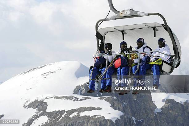 French national football team's players Bakary Sagna, Sidney Govou, Abou Diaby and Lassana Diarra sit in a ski lift upon his arrival at the top of...