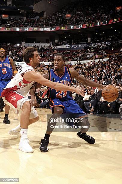 Toney Douglas of the New York Knicks dribbles against Marco Belinelli the Toronto Raptors during the game at Air Canada Centre on April 14, 2010 in...