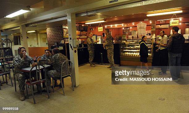 Army soldiers enjoy a drink in a coffee shop in their barracks after a Taliban attack on US air base in Bagram, 50 kms north of Kabul, on May 19,...