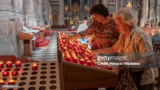 Faithful light candles in front a figure of Our Lady of Fatima in Sao Domingos church on July 13, 2018 in Lisbon, Portugal. Sao Domingos was...