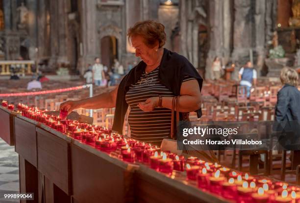 Faithful lights candles in front a figure of Our Lady of Fatima in Sao Domingos church on July 13, 2018 in Lisbon, Portugal. Sao Domingos was...