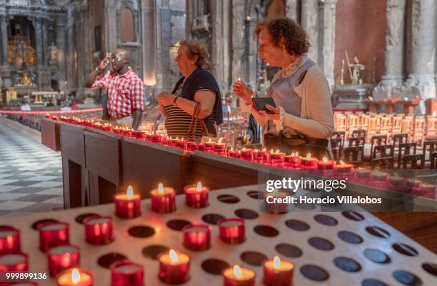 Faithful pray and light candles in front a figure of Our Lady of Fatima in Sao Domingos church on July 13, 2018 in Lisbon, Portugal. Sao Domingos was...