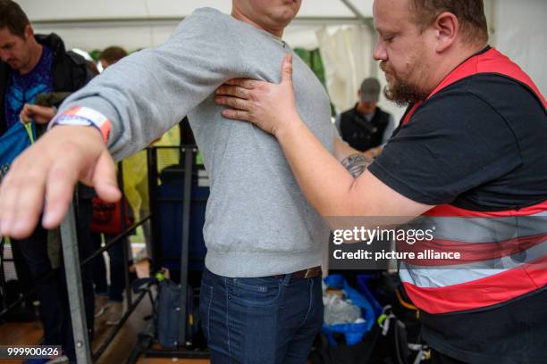 Security worker frisks a visitor at the Lollapalooza festival in Hoppegarten, Germany, 9 September 2017. The music festival is held over two days on...