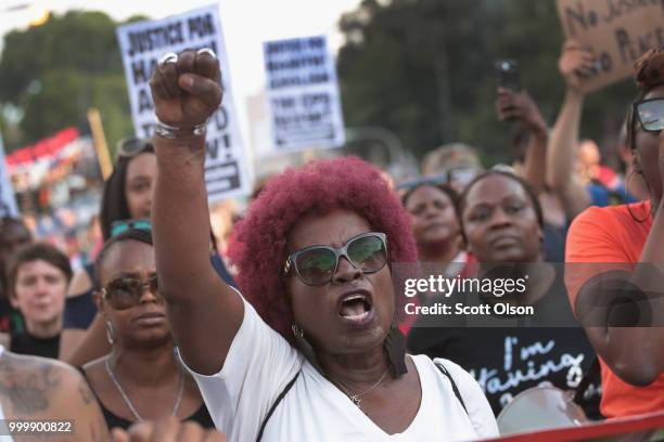 Demonstrators march through the South Shore neighborhood protesting the shooting death of 37-year-old Harith Augustus on July 15, 2018 in Chicago,...