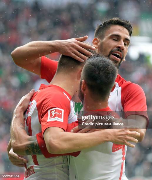 Augsburg's Rani Khedira and Alfred Finnbogason celebrate with Marcel Heller after taking a 1:0 lead during the German Bundesliga soccer match between...