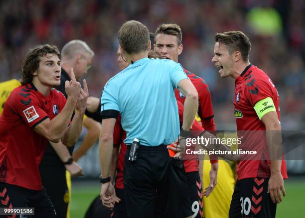 Freiburg's Caglar Söyüncü, Janik Haberer and Christian Günter argue with referee Benjamin Cortus after the latter's decision to send off thier...