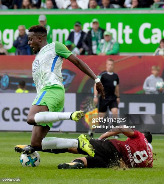 Wolfsburg's Divock Origi and Hanover's Manuel Schmiedebach vie for the ball during the German Bundesliga soccer match between VfL Wolfsburg and...